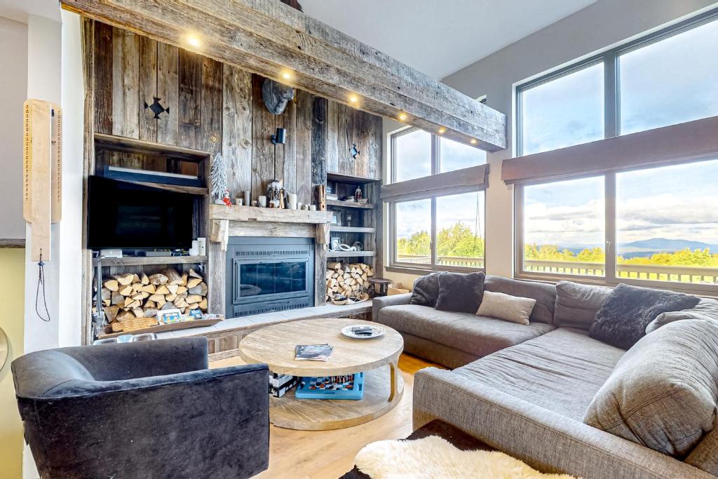 Una sala de estar con un sofá y una chimenea. en Okemo Mountain Vista, en Ludlow