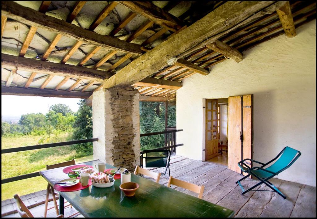 una camera con tavolo e sedie su un patio di Agriturismo Famiglia al Castello Di Bagnolo a Bagnolo Piemonte