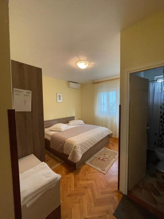 a bedroom with two beds and a door to a bathroom at Rooms Krstinić 84 in Palit