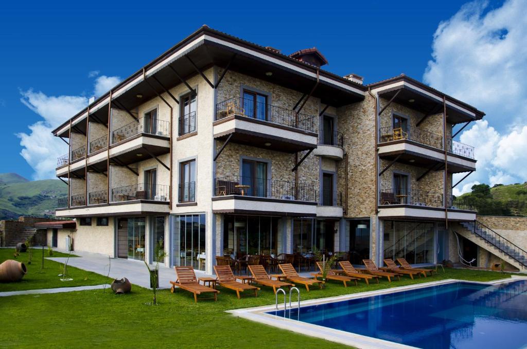 un gran edificio con una piscina frente a él en Kuzey Park Hotel en Gokceada Town