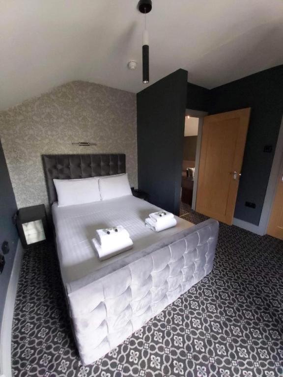 ein Schlafzimmer mit einem großen Bett mit zwei Handtüchern darauf in der Unterkunft OYO Ivy Hotel in Skegness