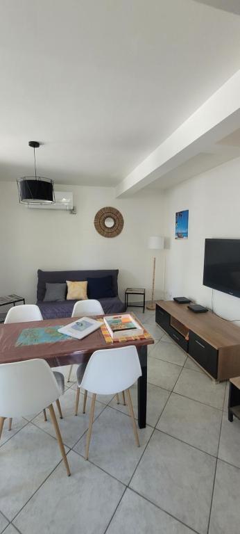 a living room with a table and a couch at Ti-Diamant Plage du Diamant- 4 Pers- Clim- WIFI in Le Diamant