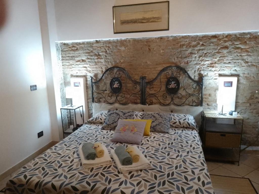 - une chambre avec un grand lit et un mur en pierre dans l'établissement IL PICCOLO EDEN - Private Garden, à Livourne
