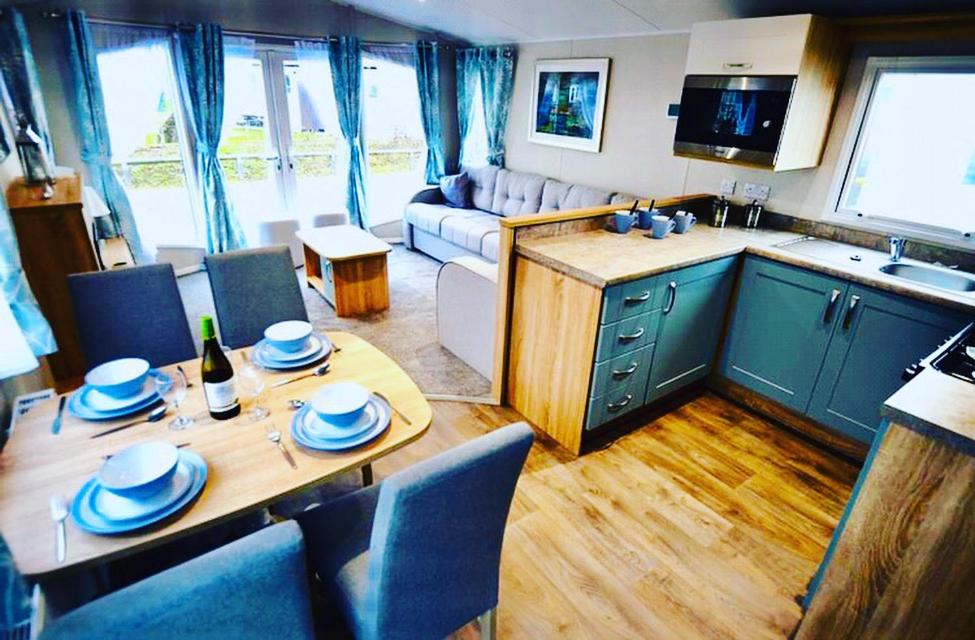 a kitchen and a living room with a table and chairs at 3 bedroom Heaven Home in Chichester
