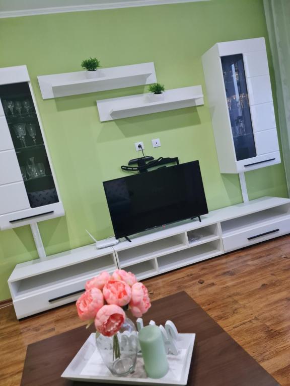 un soggiorno con TV e tavolo di Apartament modern-nou Cristina&Jessica a Mediaş