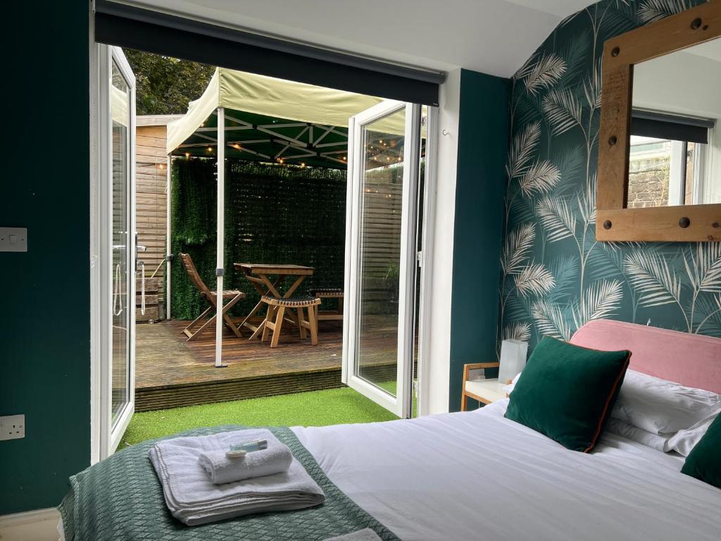 um quarto com uma cama e um pátio com uma mesa em SoHot Stays Stylish & Cosy with Hot Tub & Log Burner, Margate em Margate