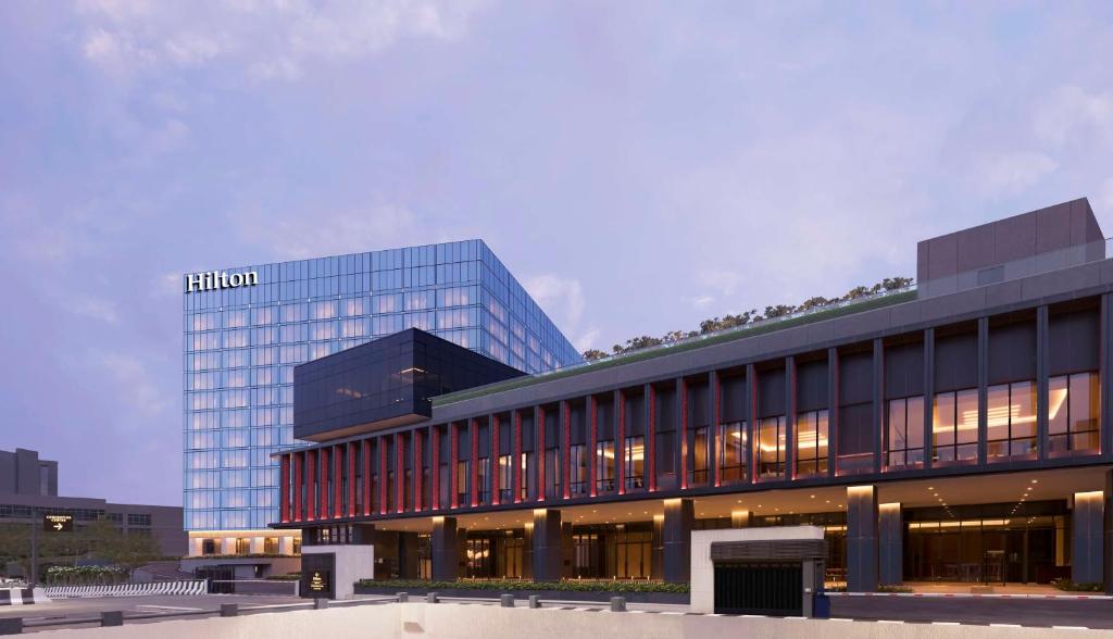 Hilton Bengaluru Embassy Manyata Business Park في بانغالور: مبنى عليه علامة هيلتون