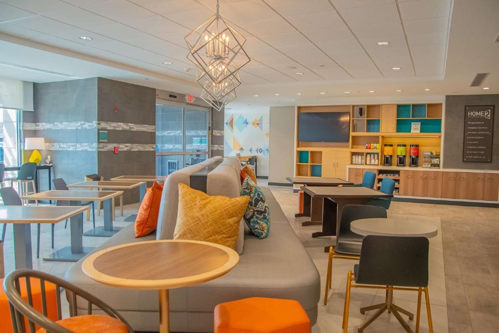 a waiting room with tables and chairs and a couch at Home2 Suites By Hilton Logansport in Logansport