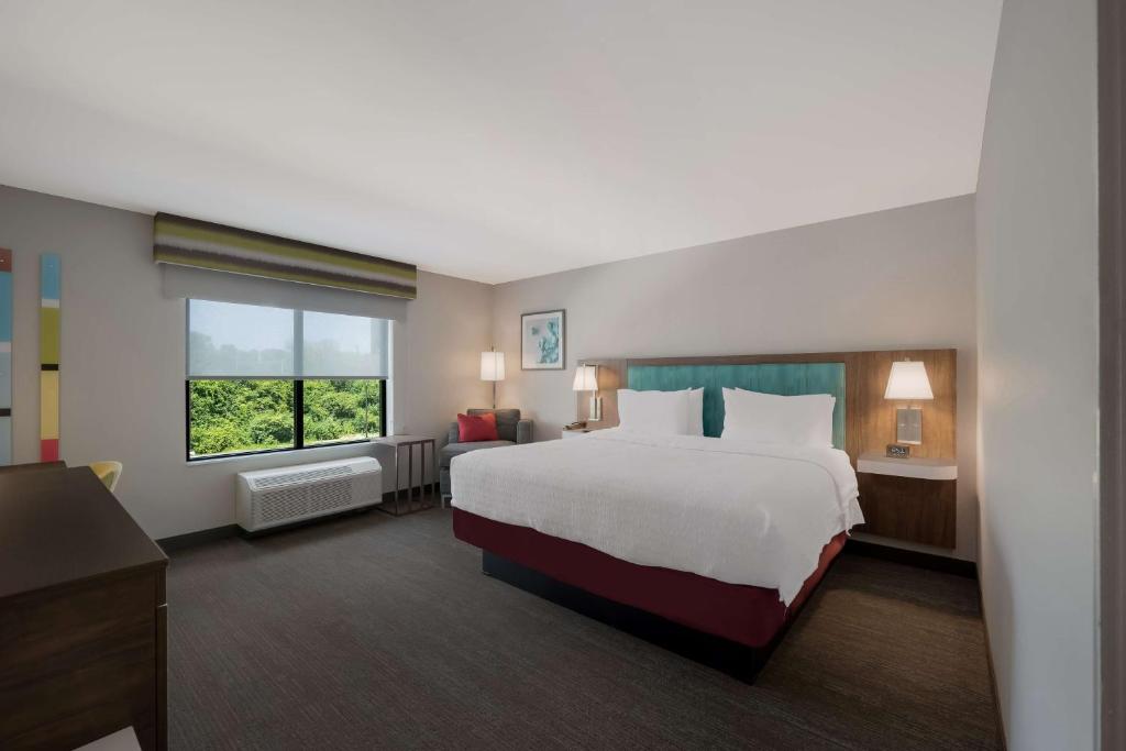 a hotel room with a large bed and a window at Hampton Inn by Hilton Detroit Southfield in Southfield