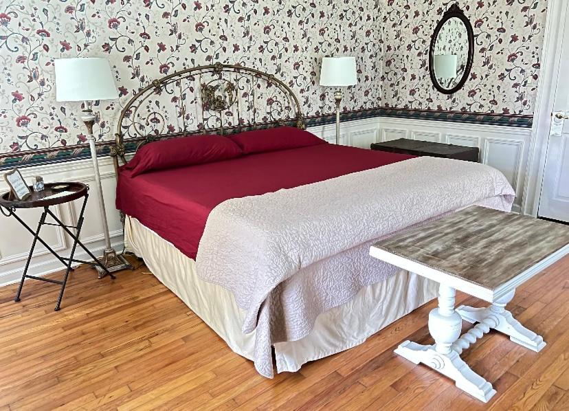 a bedroom with a bed and a table in it at Historic Seaton Springs Farm B&B - J Seaton King Room & Private Bath in Sevierville