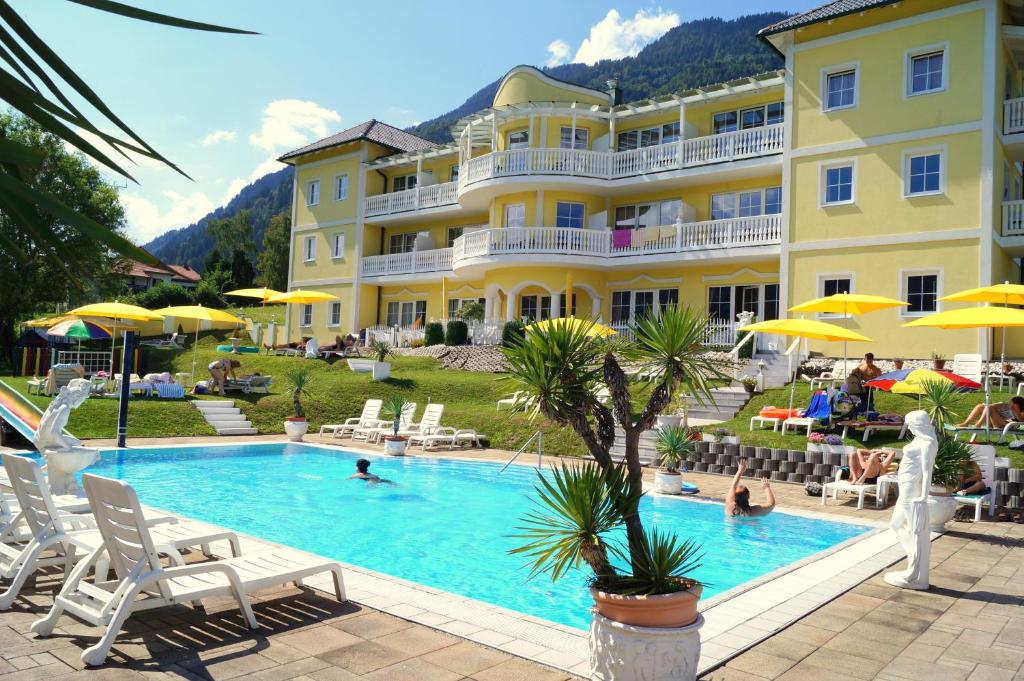 un hôtel avec une piscine en face d'un bâtiment dans l'établissement All Inclusive Hotel Sonnenhügel, à Sattendorf
