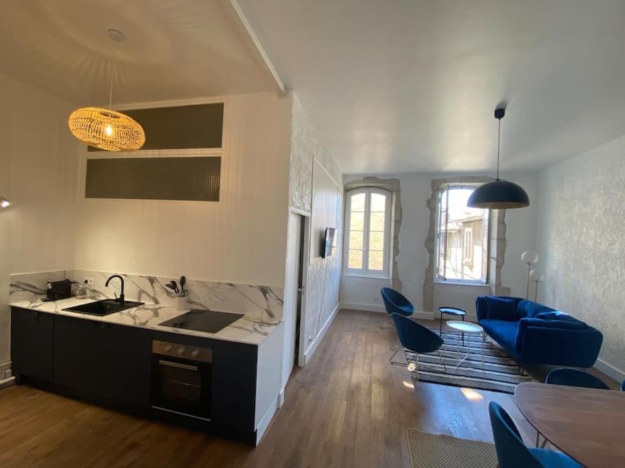Il comprend une cuisine et un salon avec un évier et des chaises bleues. dans l'établissement Superbe T3 neuf centre-ville, à Nîmes