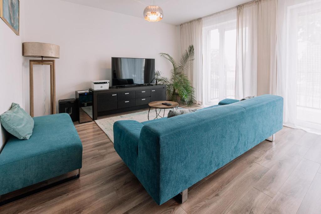 uma sala de estar com um sofá azul e uma televisão em REVON Business apartment Senec em Senec