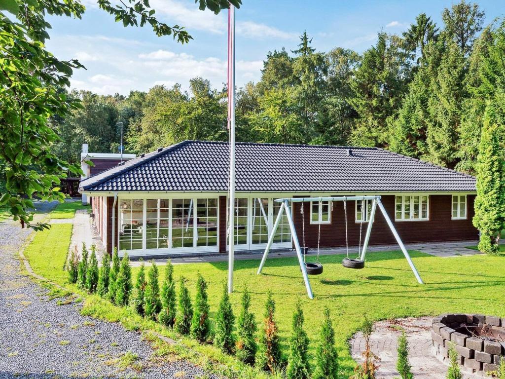 een gebouw met een speeltuin ervoor bij Holiday Home Brinken in Frederiksværk