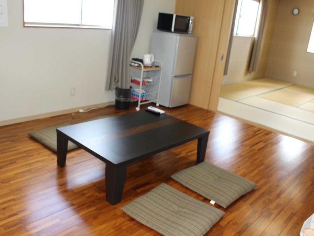 a living room with a table and a refrigerator at Yugaku Resort Kimukura - Vacation STAY 93873v in Tokunoshima
