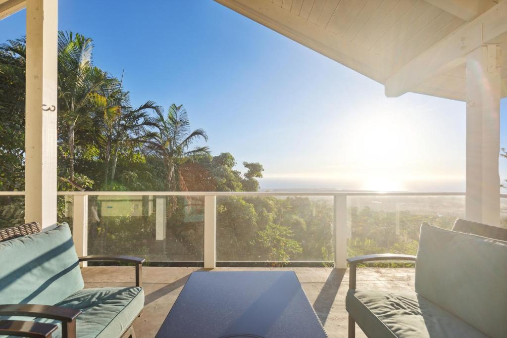 een veranda met stoelen en een tafel en uitzicht op de oceaan bij Pu'ukala Sunset Estate with Amazing Ocean Views! home in Kailua-Kona