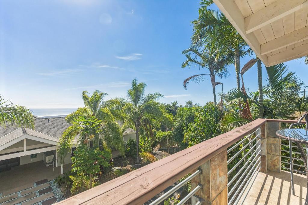 a view from the balcony of a house with palm trees at Charming Pu'ukala Sunset - Near Hiking and Golf home in Kailua-Kona