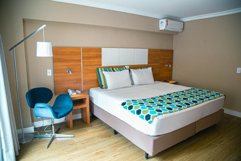 um quarto com uma cama, uma secretária e uma cadeira em Dubai Macaé by Atlântica em Macaé
