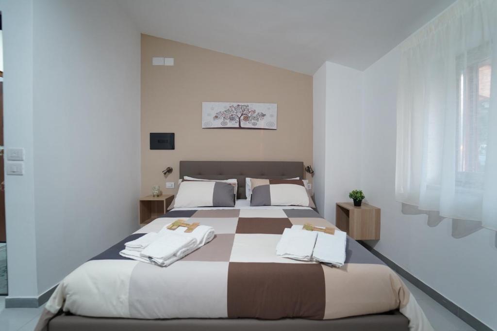um quarto branco com uma cama grande e toalhas em Cerchia Apartments em Corbara