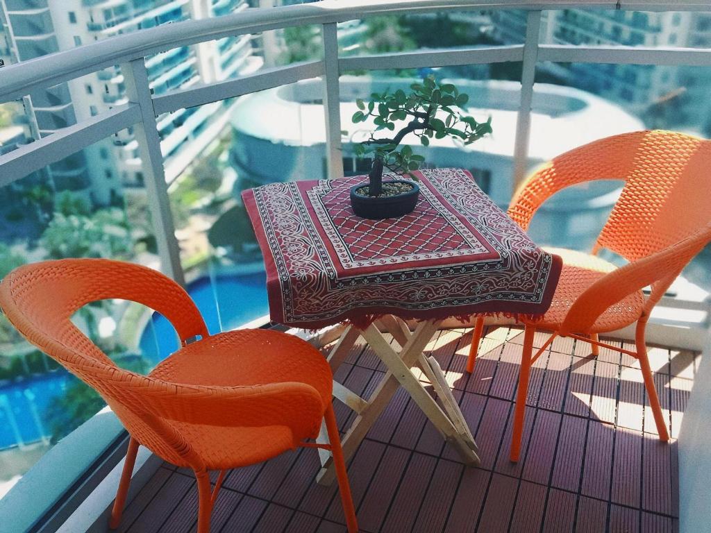 a table and chairs on a balcony with a plant on it at Manila Urban Resort at Azure in Manila