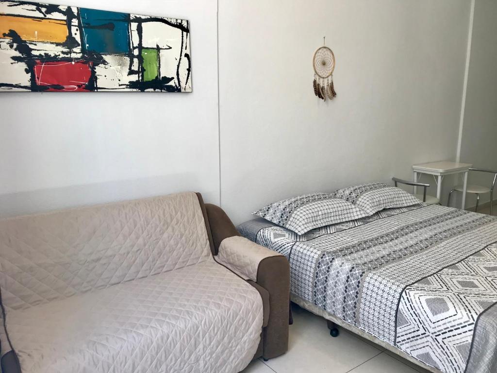 a bedroom with a bed and a couch at Apartamento Copacabana Posto5 in Rio de Janeiro