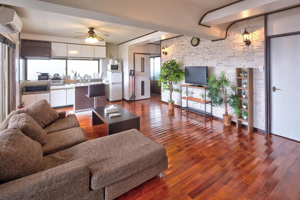 ein Wohnzimmer mit Couch und Küche in der Unterkunft Wind Henza - Vacation STAY 73122v in Uruma