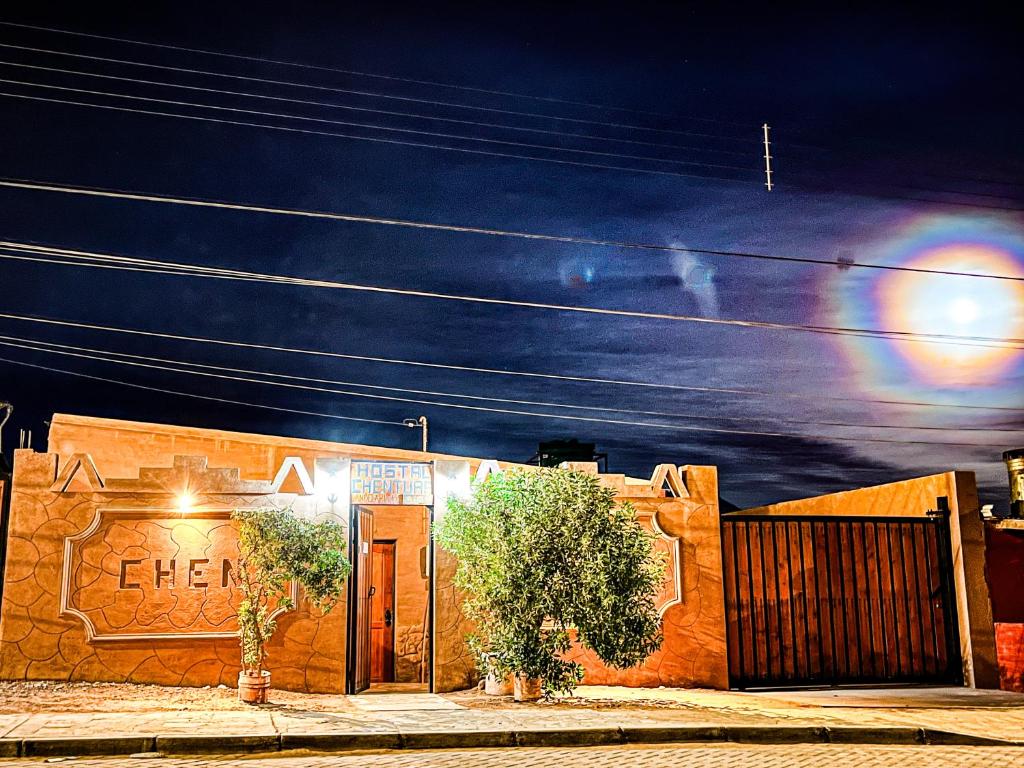 un bâtiment avec un panneau la nuit dans l'établissement Hostal Qachi Chentura, à San Pedro de Atacama