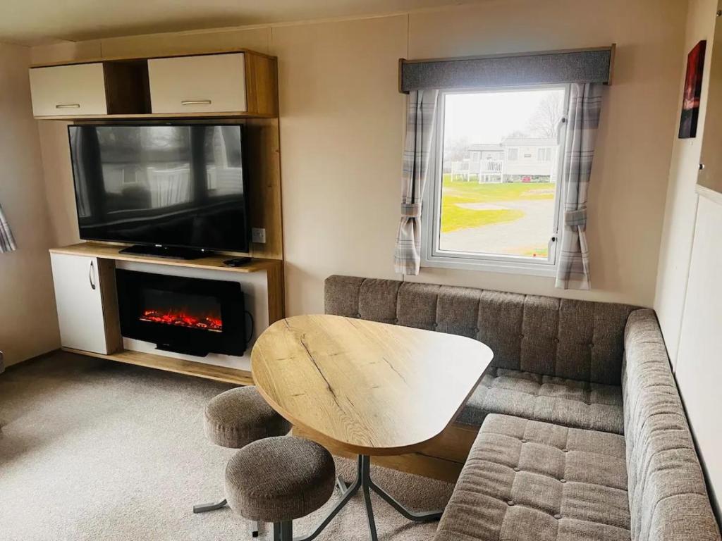 a living room with a couch and a fireplace at Kent Coast 3 bedroom holiday home in Rochester