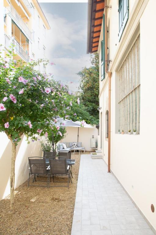 a courtyard with a table and chairs and a tree at A casa di Giuly in Florence