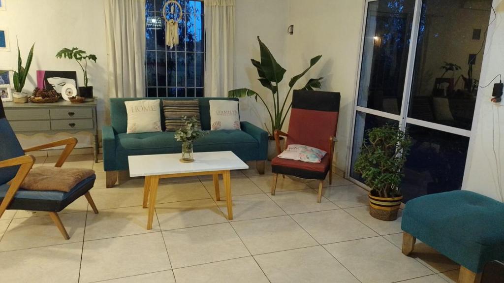 a living room with a couch and chairs and a table at Eucalipto in Mar del Plata