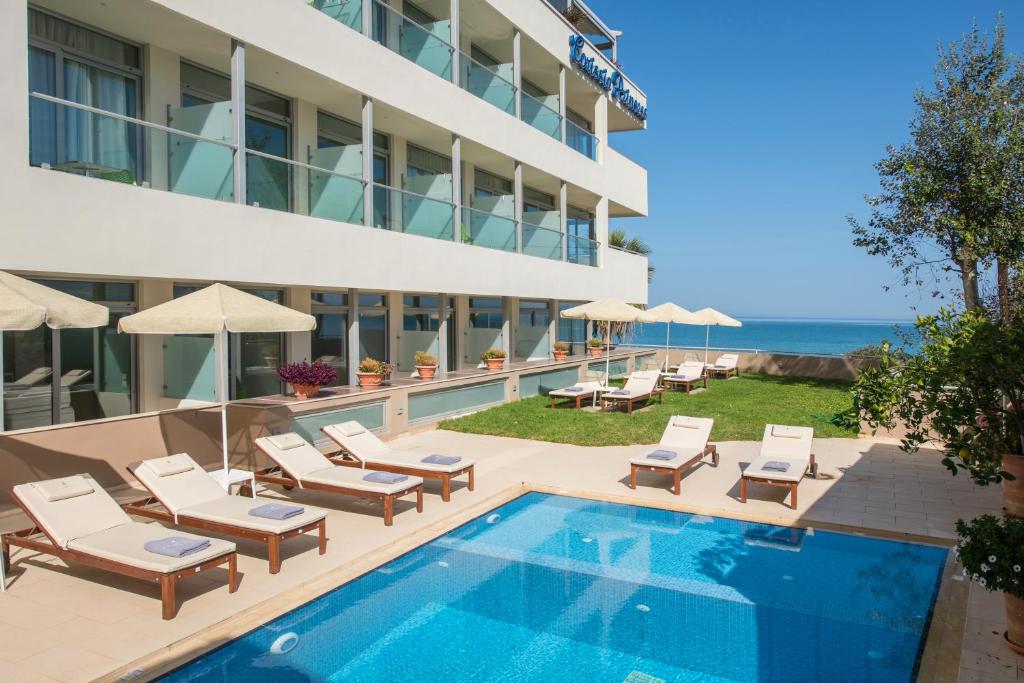 une image d'un hôtel avec une piscine et des chaises dans l'établissement Corissia Princess Hotel , à Georgioúpoli