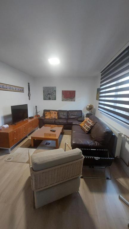 ein Wohnzimmer mit Sofa und Tisch in der Unterkunft AS Apartman Visoko in Visoko
