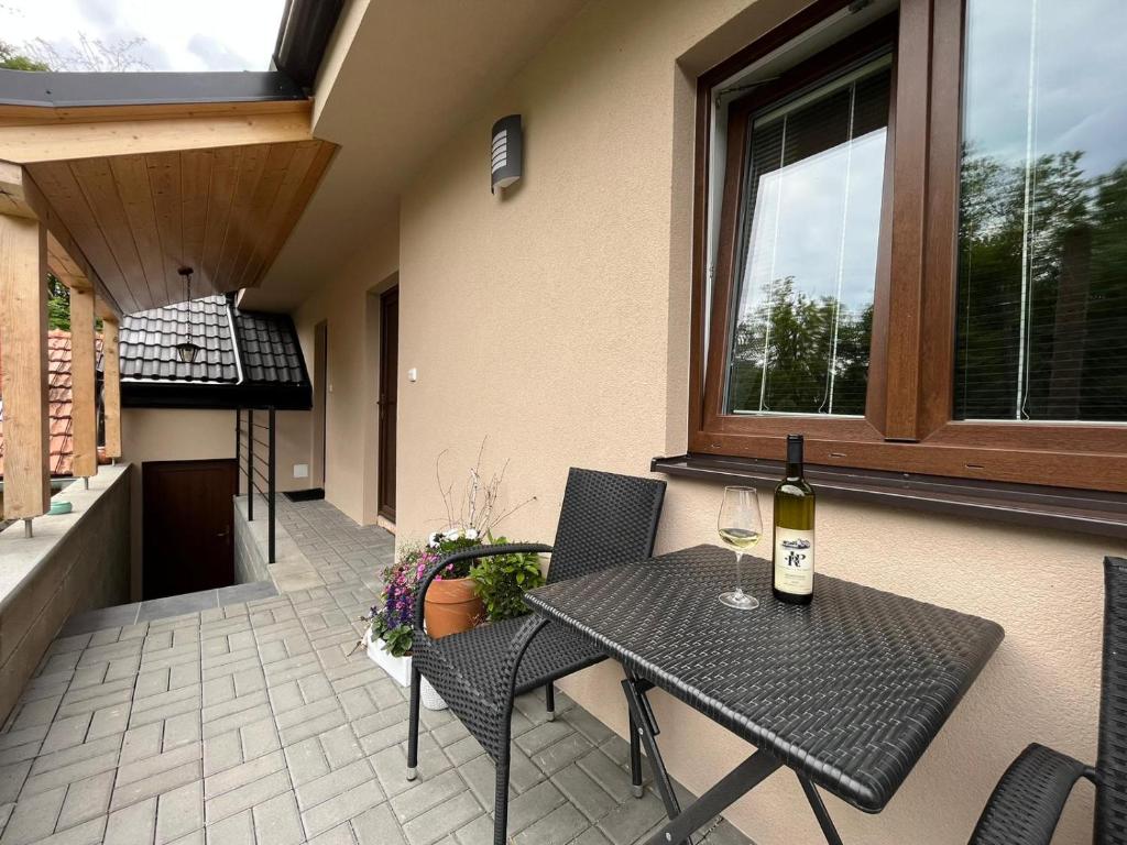 a patio with a table and chairs and a bottle of wine at U Rybnikářů in Znojmo