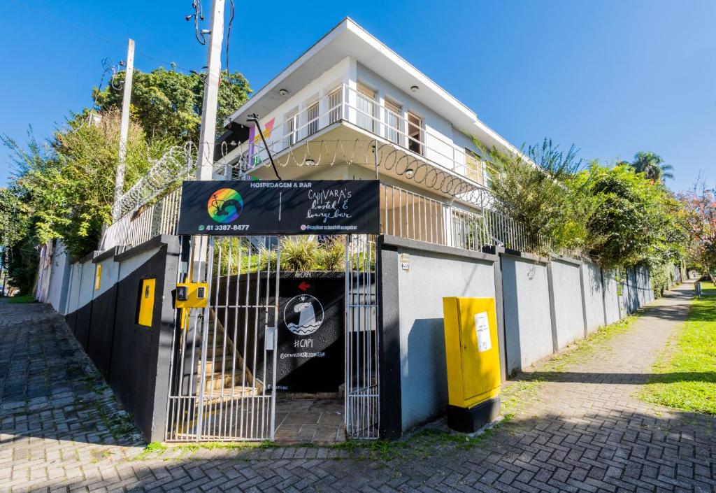 a house with a gate in front of it at Hostel Capivara's Lounge Bar in Curitiba