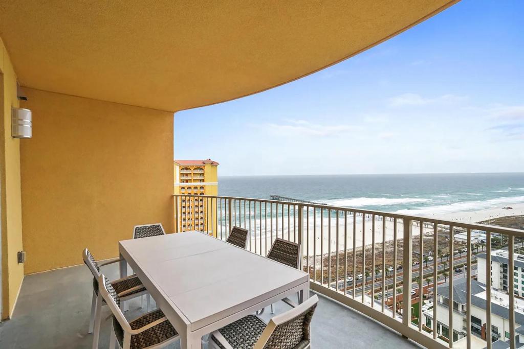 a balcony with a table and chairs and the ocean at Calypso 3-2210 - Love Nest in Panama City Beach