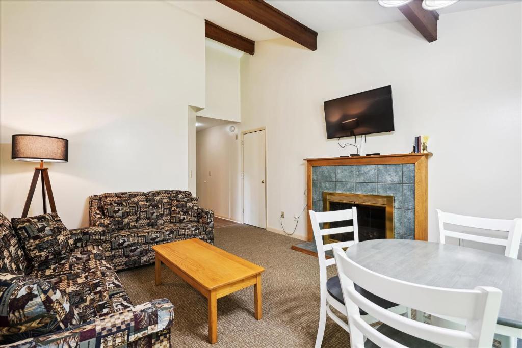 a living room with a table and a fireplace at Cedarbrook Queen Suite 106 in Killington