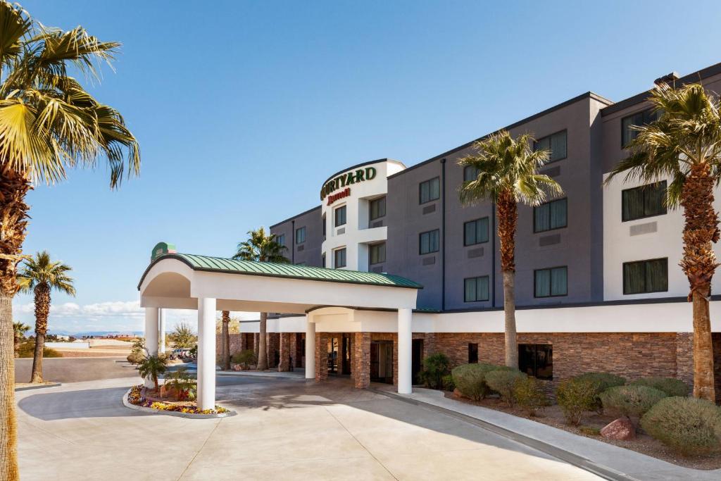 a hotel with palm trees in front of it at Courtyard By Marriott Las Vegas Stadium Area in Las Vegas