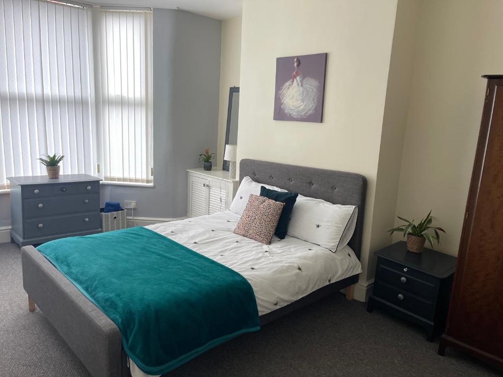 a bedroom with a large bed with a blue blanket at Marks Place in Liverpool