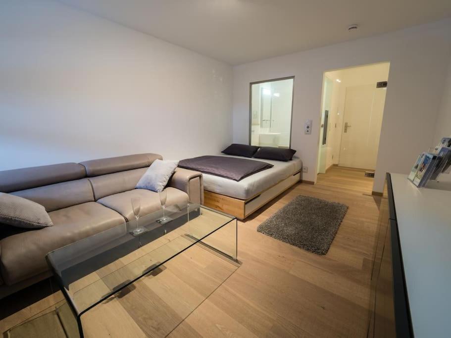 a living room with a couch and a glass table at Tegernsee - Tolles, zentrales Appartement in Tegernsee