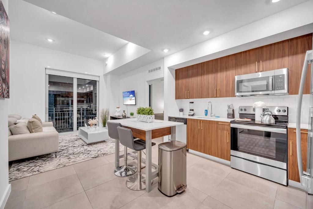 uma cozinha e sala de estar com uma mesa e um sofá em Modern Unit in the Heart of Downtown Miami With Free Parking em Miami