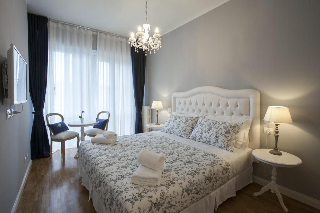 sypialnia z białym łóżkiem i żyrandolem w obiekcie B&B La Nannina we Florencji