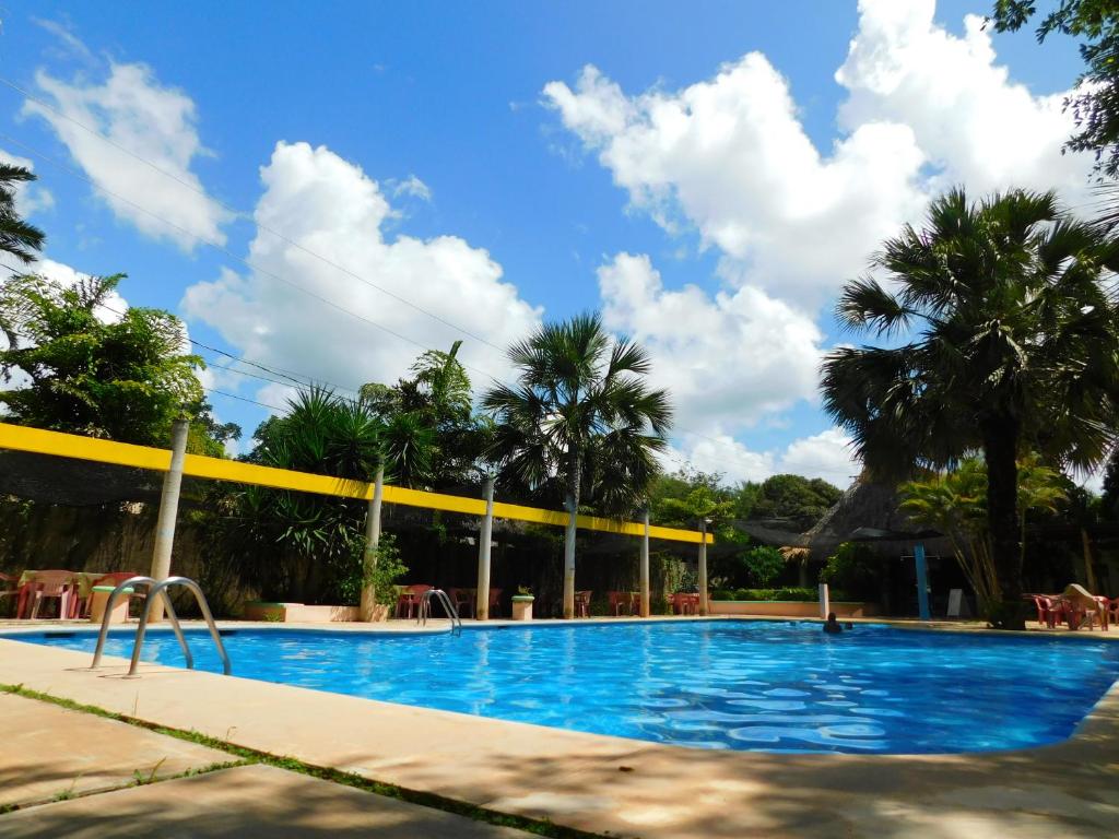 uma piscina num resort com palmeiras em Centro Social Ecoturistico La Alberca em Jose Maria Morelos