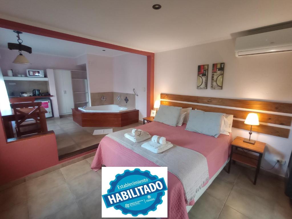 Habitación de hotel con cama y bañera en Ruca Lemu en Chascomús