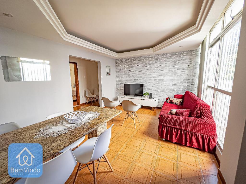 sala de estar con sofá rojo y mesa en Apartamento Aconchegante no Rio Vermelho, en Salvador