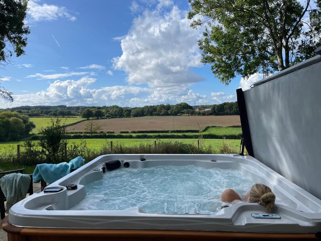 Un niño en un jacuzzi con vistas en The Georgian Coach House:New Forest with hot tub, en Fordingbridge