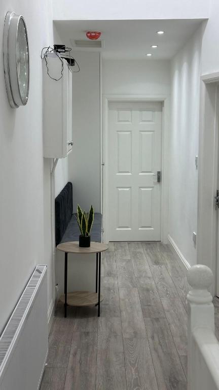 un couloir avec une table et une porte blanche dans l'établissement 179 church Road, à Londres