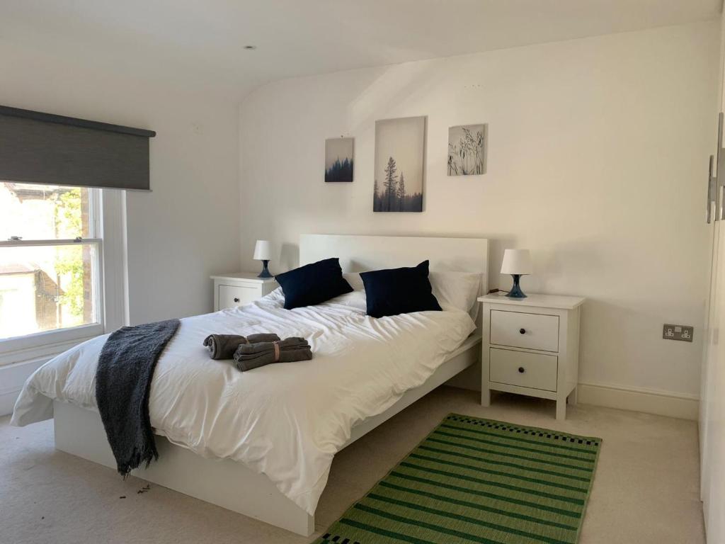 a bedroom with a white bed and a green rug at Delightful new ensuite bedroom with stunning shared kitchen & living room -1C The Charteris in London