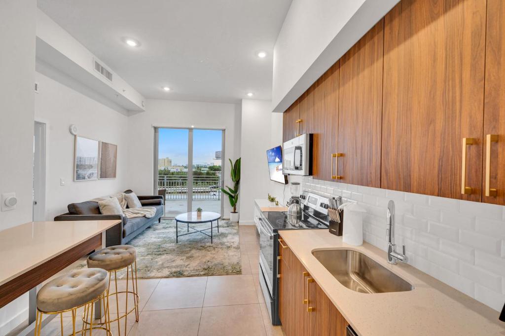 a kitchen with a sink and a living room at Modern Unit in Downtown Miami With Free Parking in Miami