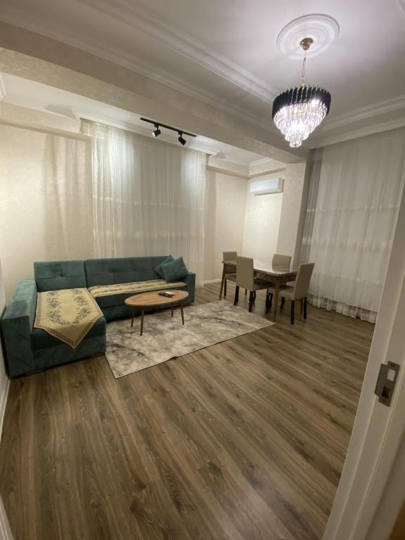 sala de estar con sofá y mesa en Гостевая Квартира, en Sumqayit