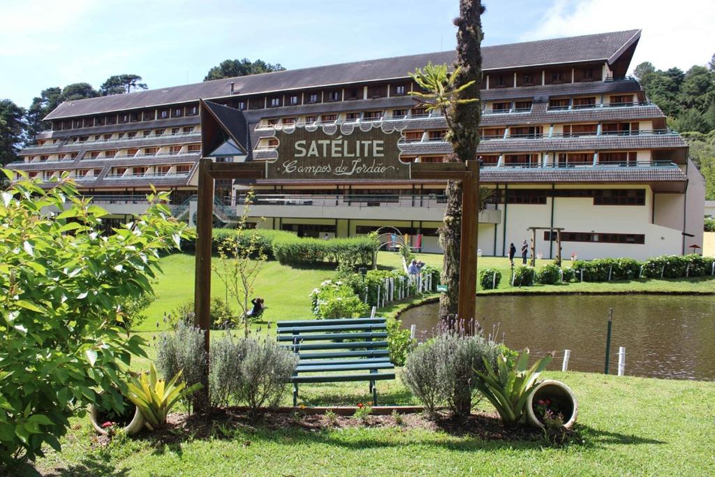 a hotel with a bench in front of a building at Satélite - Campos do Jordão in Campos do Jordão